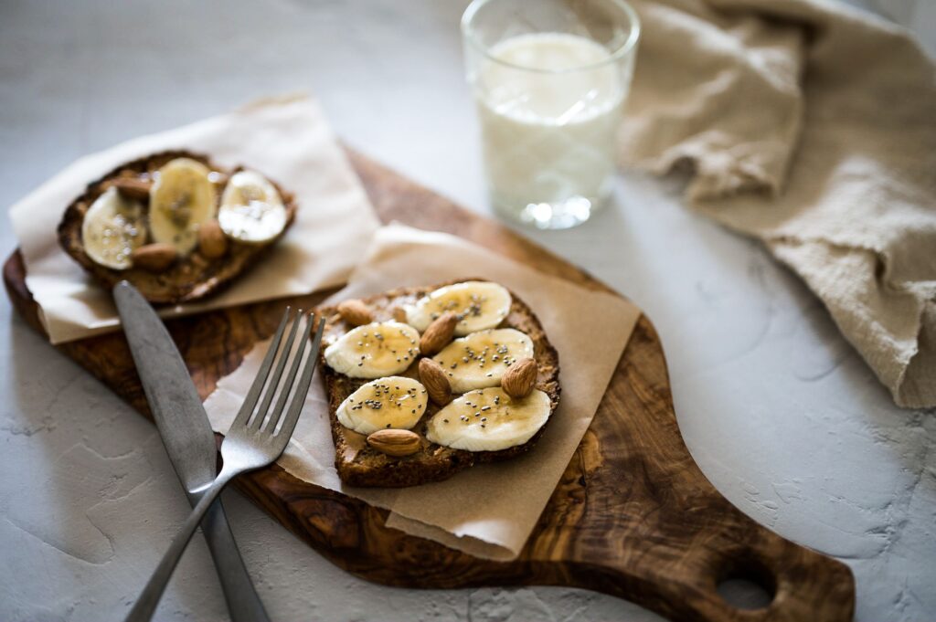 Banana slices arranged over creamy peanut butter toast
